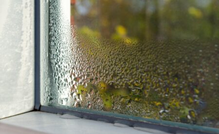 Closeup Of A Home’s Glass Window Blurred By Water Drops Collecting, Signaling The Need For Air Dehumidification.