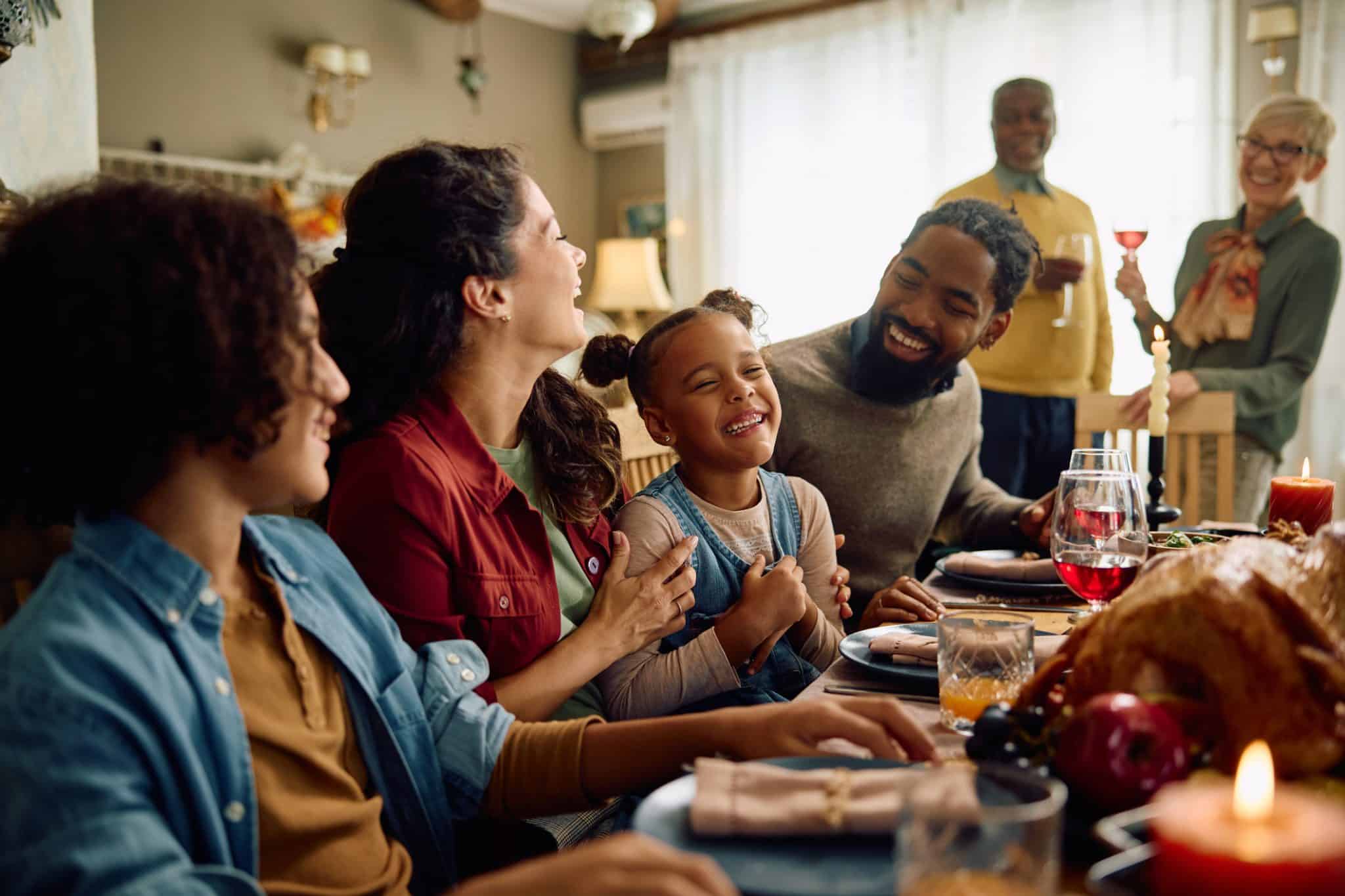 A family celebrating the holiday season sits together to enjoy a festive meal, unaware that their indoor air quality is plummeting.