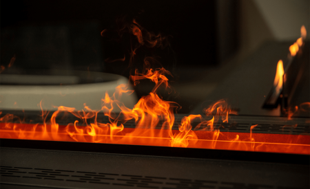 A tight shot on a gas fireplace with flames rising out of the firebox.