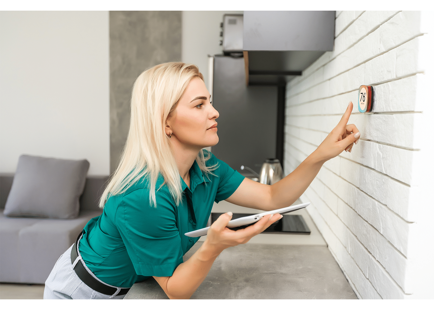 Smart home digital thermostat touch screen woman touching touchscreen to adjust temperature of heating in living room wall