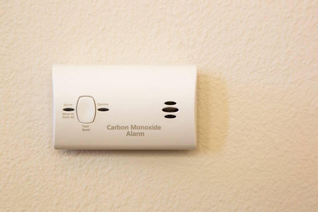 A carbon monoxide alarm on a wall in a house—an essential device to reduce the risk of CO poisoning from a faulty furnace.