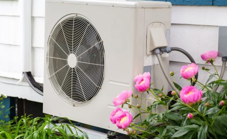 Outdoor AC unit beside a home in spring as warmer weather arrives in DFW.