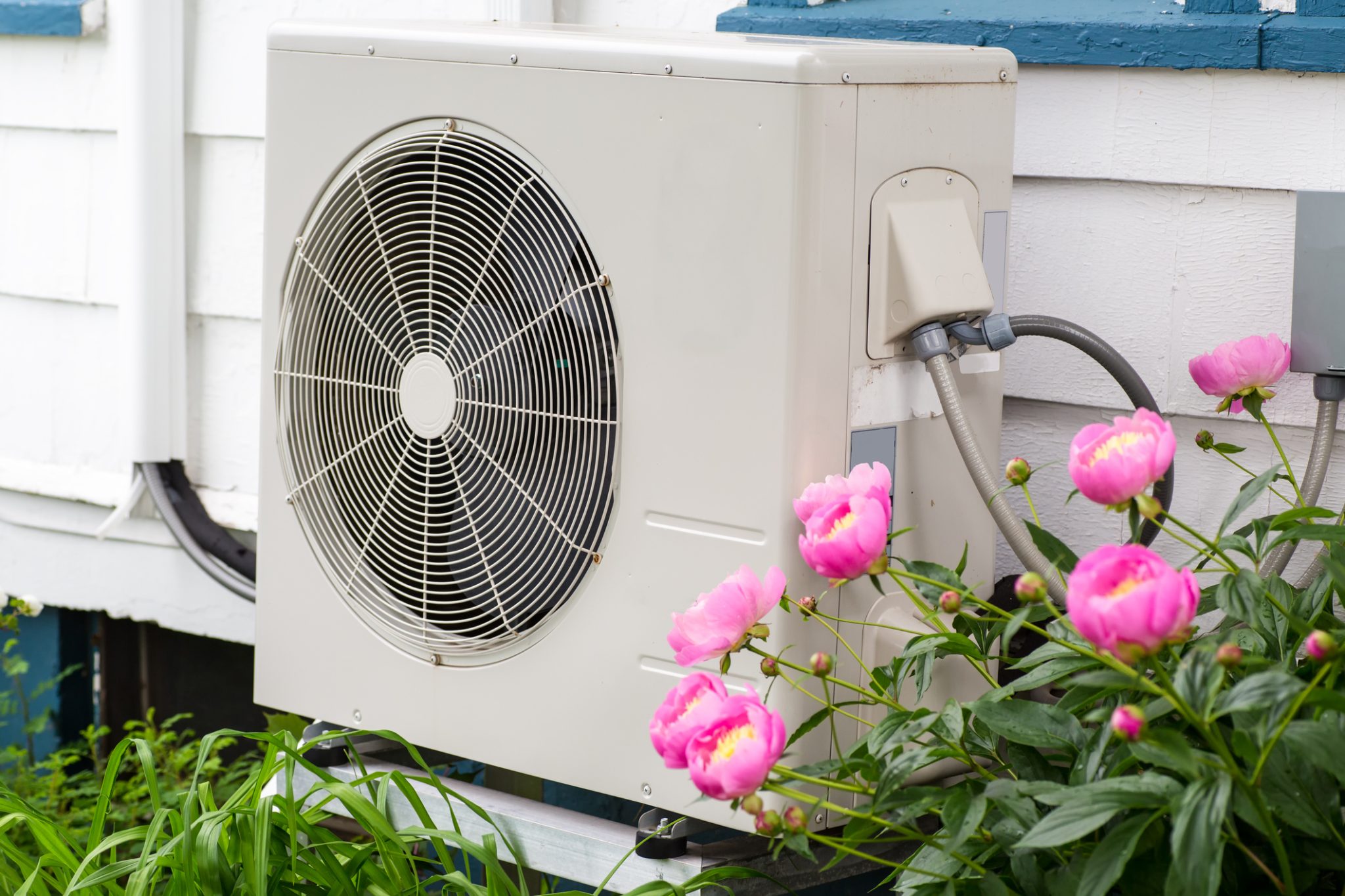 Outdoor AC unit beside a home in spring as warmer weather arrives in DFW.