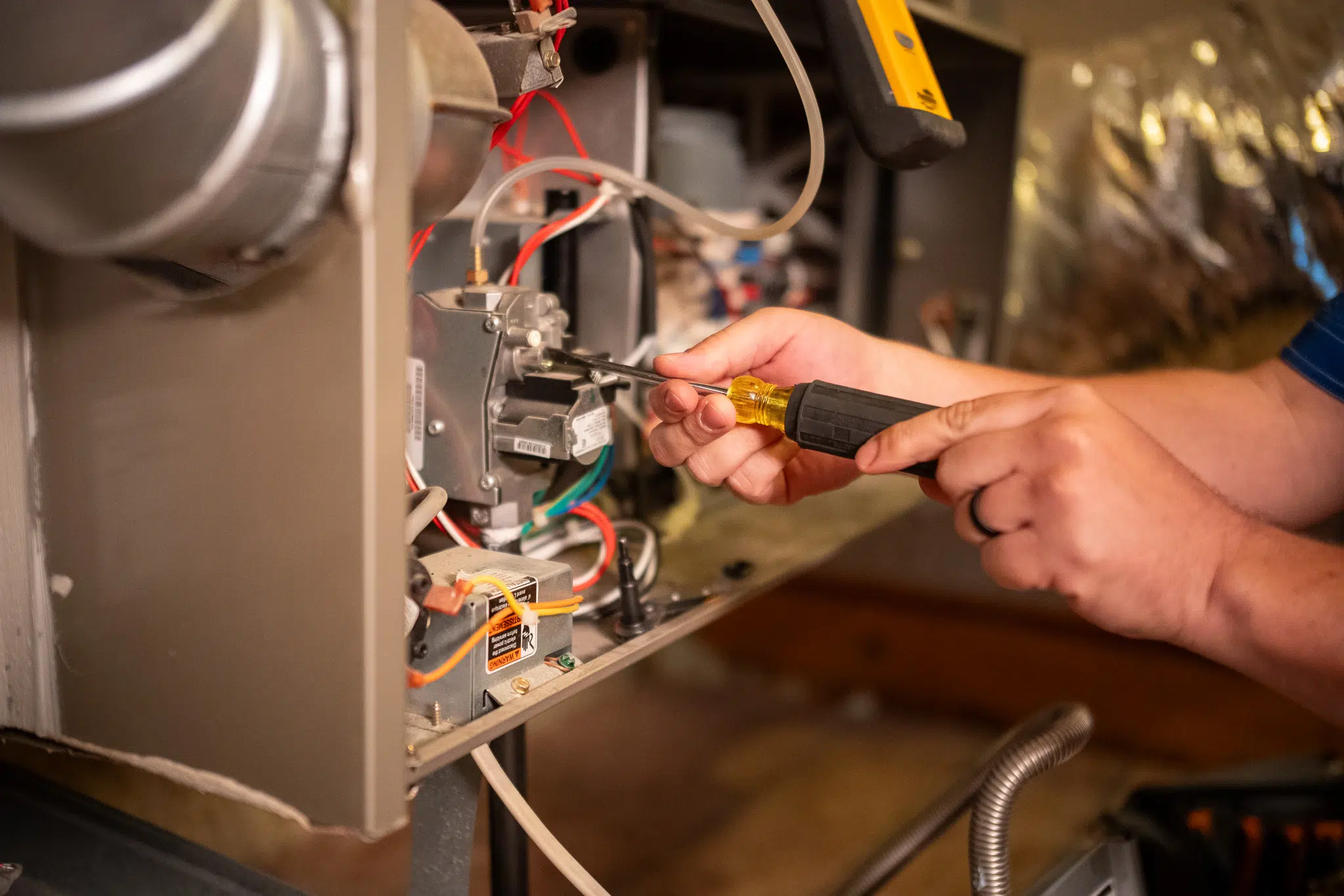 Houk technician performing interior AC repair on a residential HVAC system.