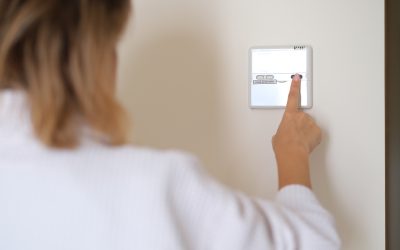 A DFW homeowner adjusting her thermostat to cool her home during spring weather.