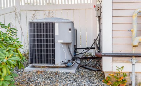 A standard AC unit showing wear, a sign it's ready for a high-efficiency replacement.