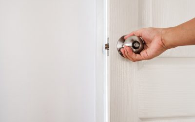 A hand closing a white interior bedroom door, the everyday habit that can restrict a home's airflow