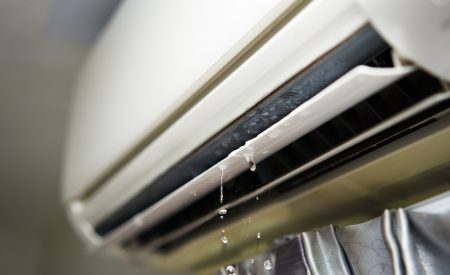 Water leaking from an indoor AC unit vent, a sign of water around an AC unit that needs attention.