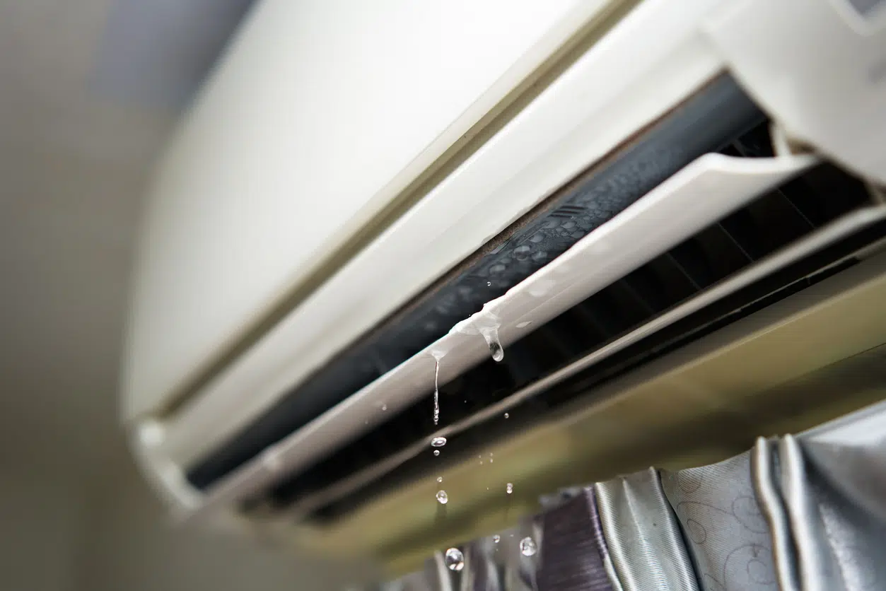 Water leaking from an indoor AC unit vent, a sign of water around an AC unit that needs attention.
