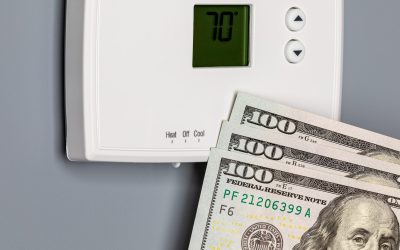 Cash tucked beside a home thermostat, representing what HVAC installation and AC replacement can cost DFW homeowners.