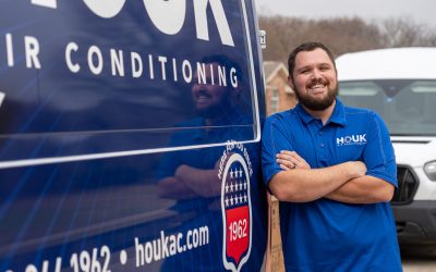 Houk Air Conditioning technician beside a branded van before an HVAC consultation