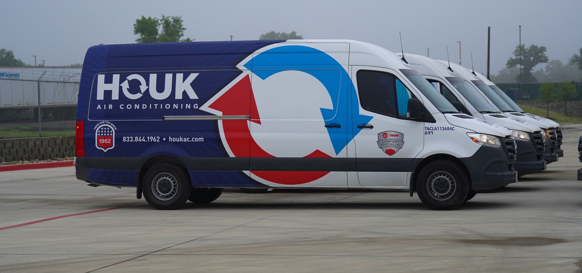 Houk Air Conditioning's newest service van with the Houk fleet lined up behind it